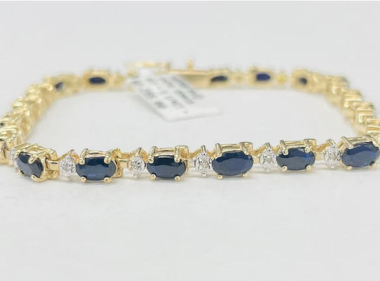 There is a gold bracelet with sapphires and diamonds.