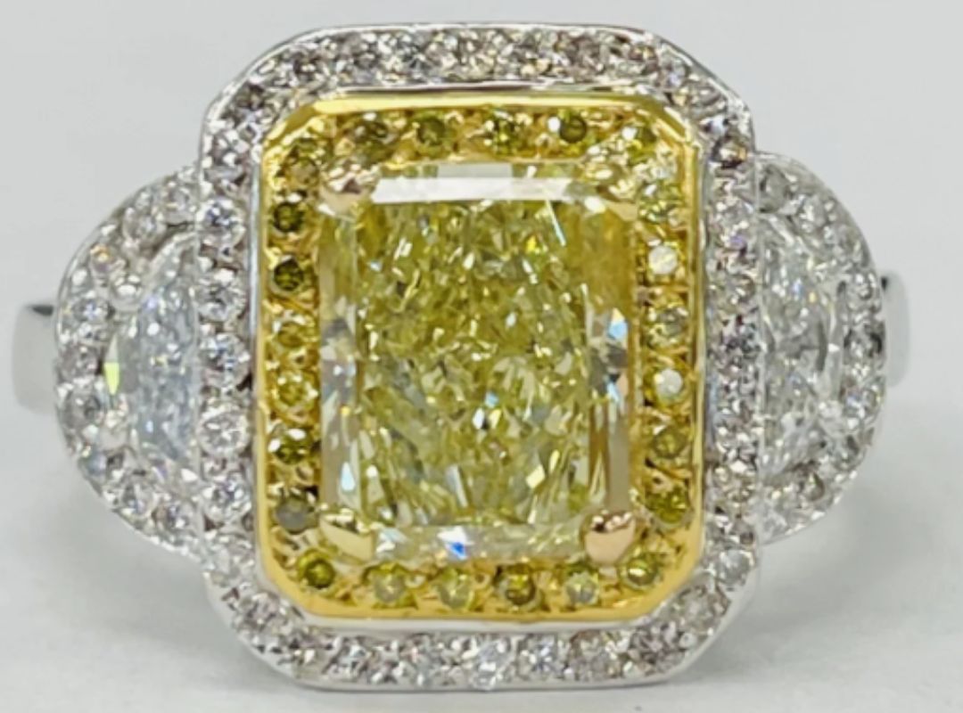 There is a diamond ring with a large yellow diamond in the middle and then many small diamonds on the sides.
