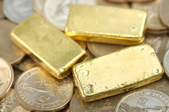 Gold bars and coins on a textured surface