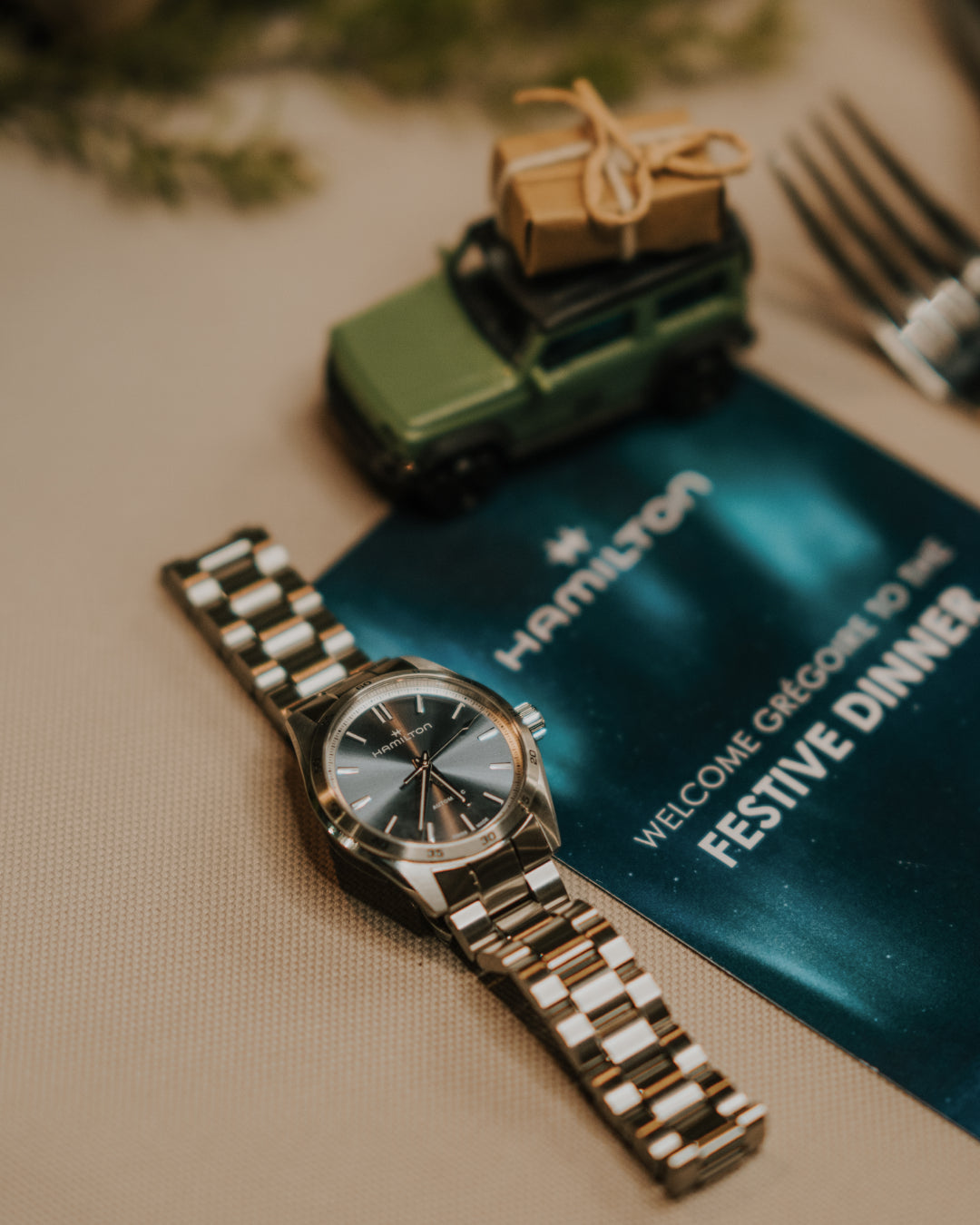 Hamilton watch on a table with a decorative card and toy car