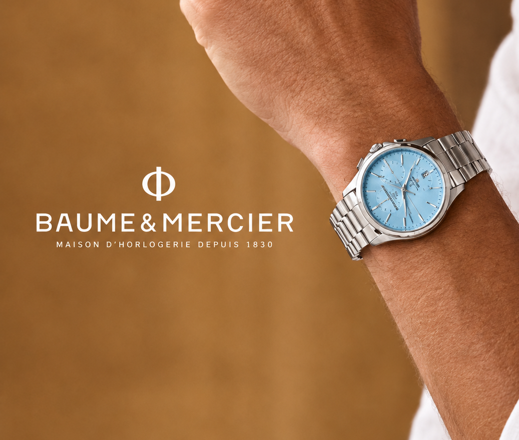 A Baume & Mercier wristwatch with a silver metal bracelet and a light blue dial, worn on a person's wrist. The image features a warm brown textured background and the Baume & Mercier brand logo and name on the left side.