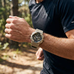 Person wearing a G-Shock watch outdoors with a blurred natural background
