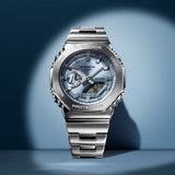 Silver Casio G-Shock watch on a blue gradient background