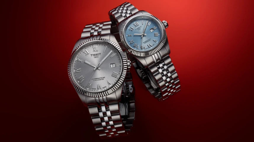 Two TISSOT silver watches on a red background