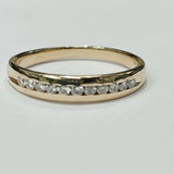 This delicate diamond channel band features a 14k yellow gol...