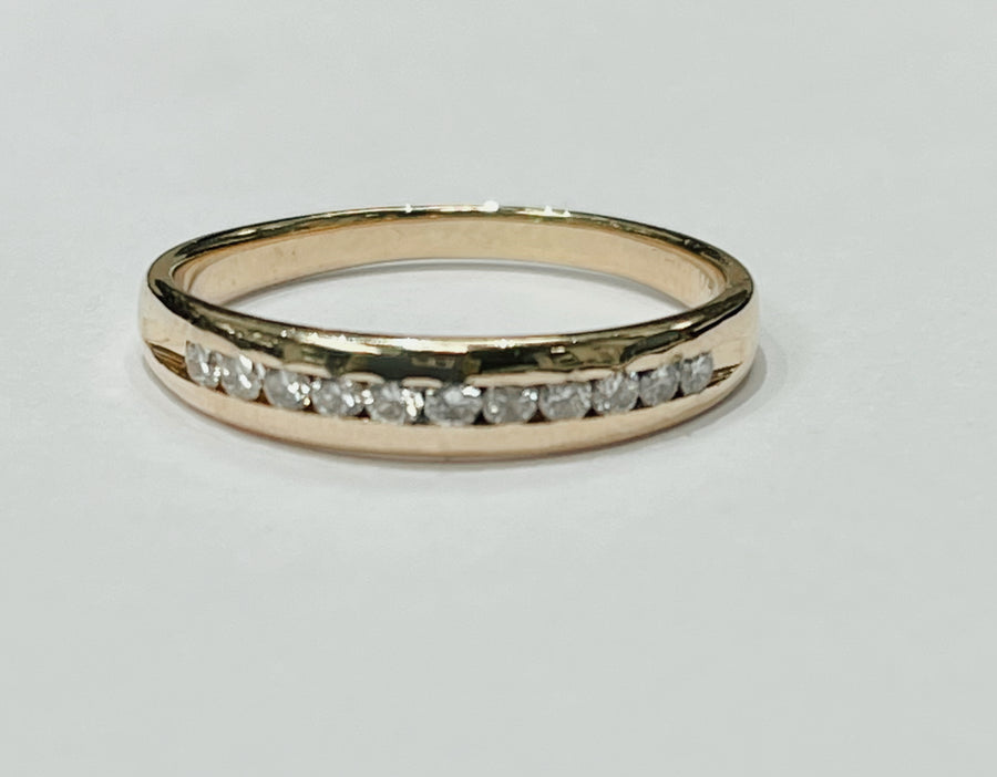 This delicate diamond channel band features a 14k yellow gol...